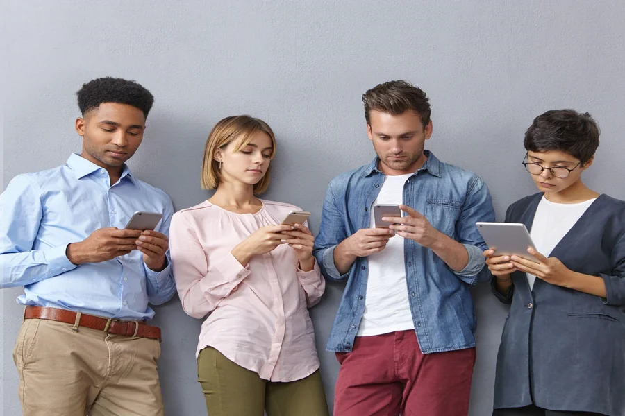 A group of people keeping themselves busy by using mobile devices.